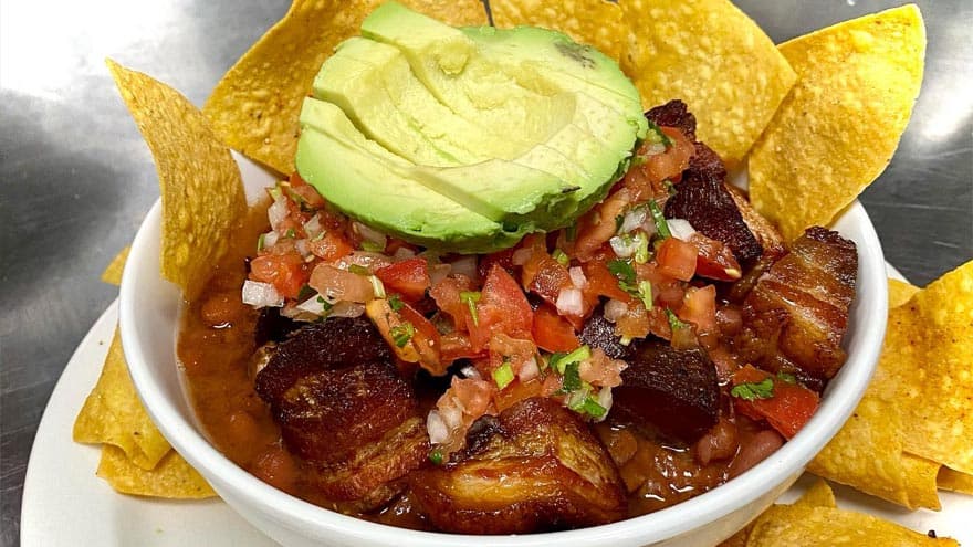 Chifrijo — rice, beans, crispy chicharrón and pico de gallo. The official snack of every Tico bar.